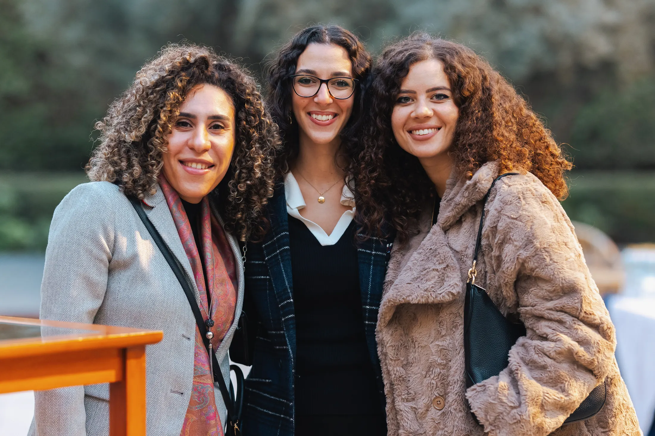 Three PGAE alumnae reconnecting outdoors.